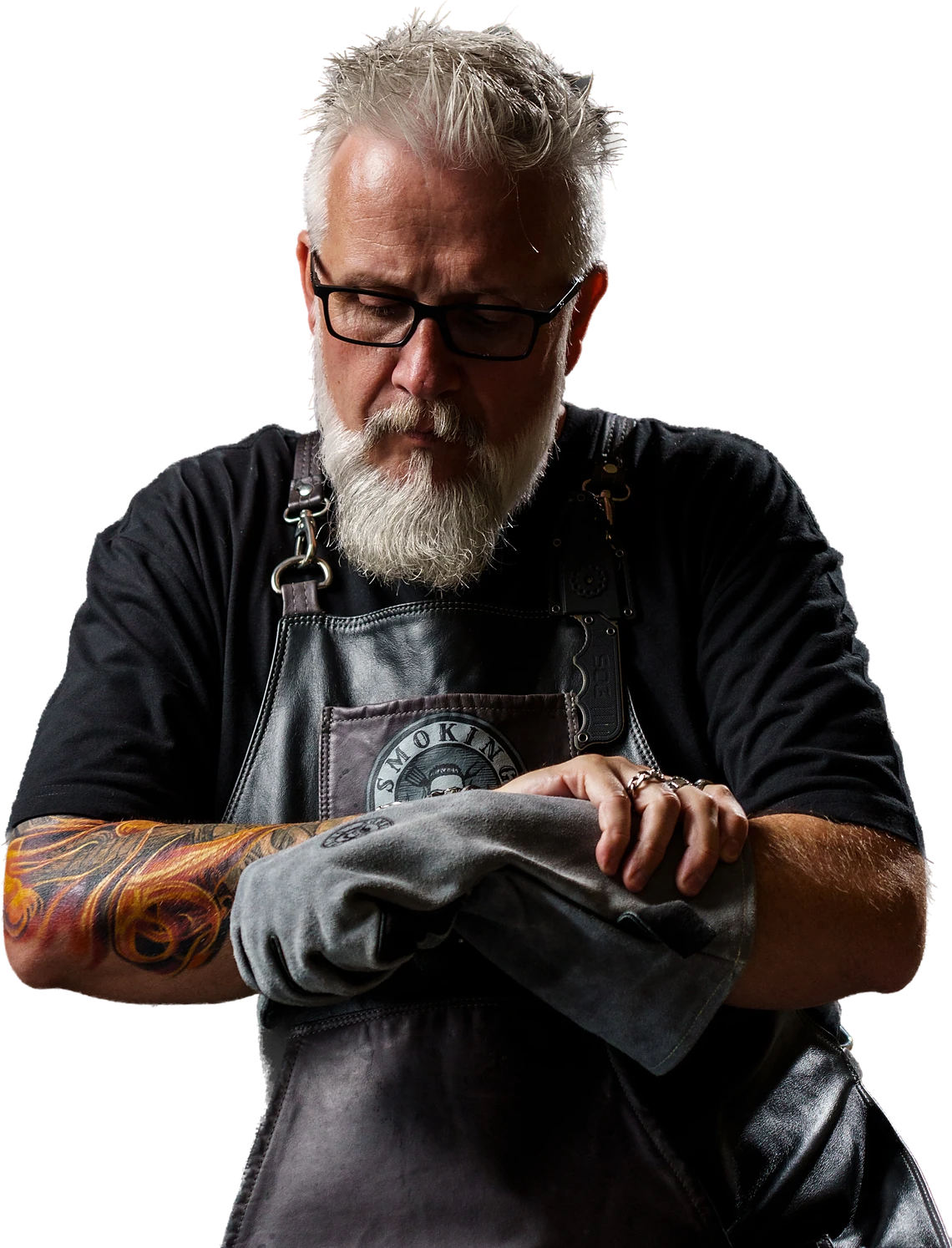 Frederic Casagrande in a leather apron, drying his hands on a cloth beside the fire